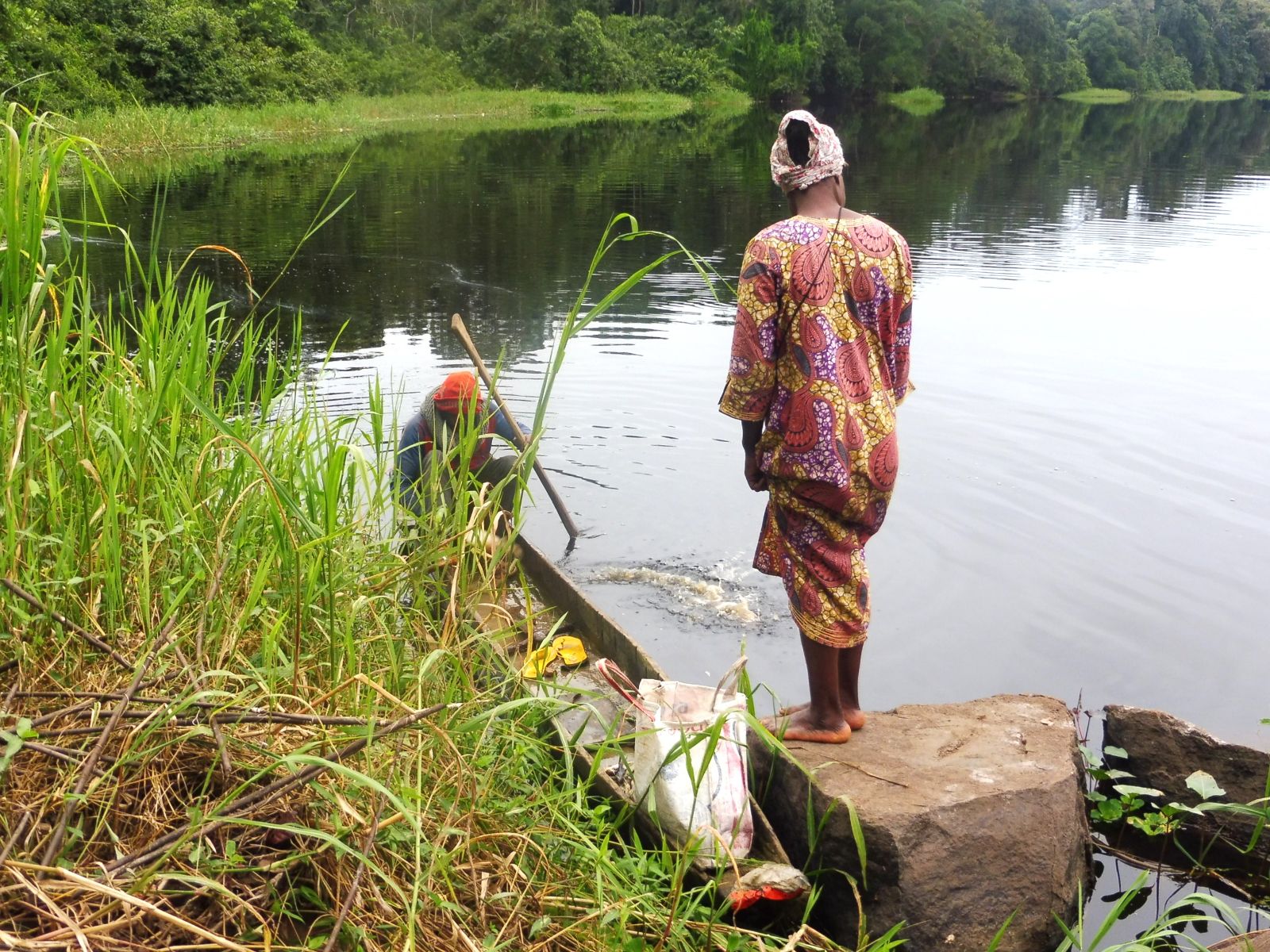 Une femme descend de la pirogue